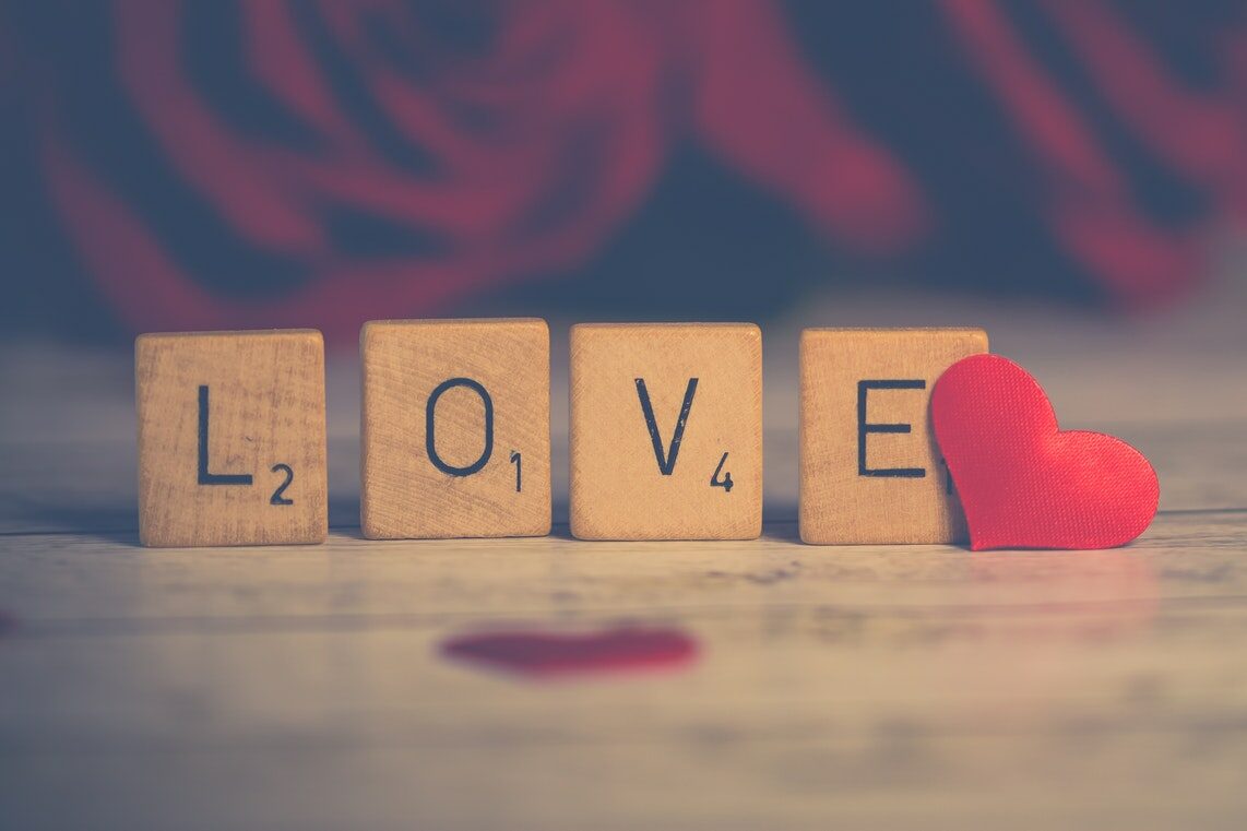 Nahaufnahme der hölzernen Scrabble-Kacheln in Herznähe