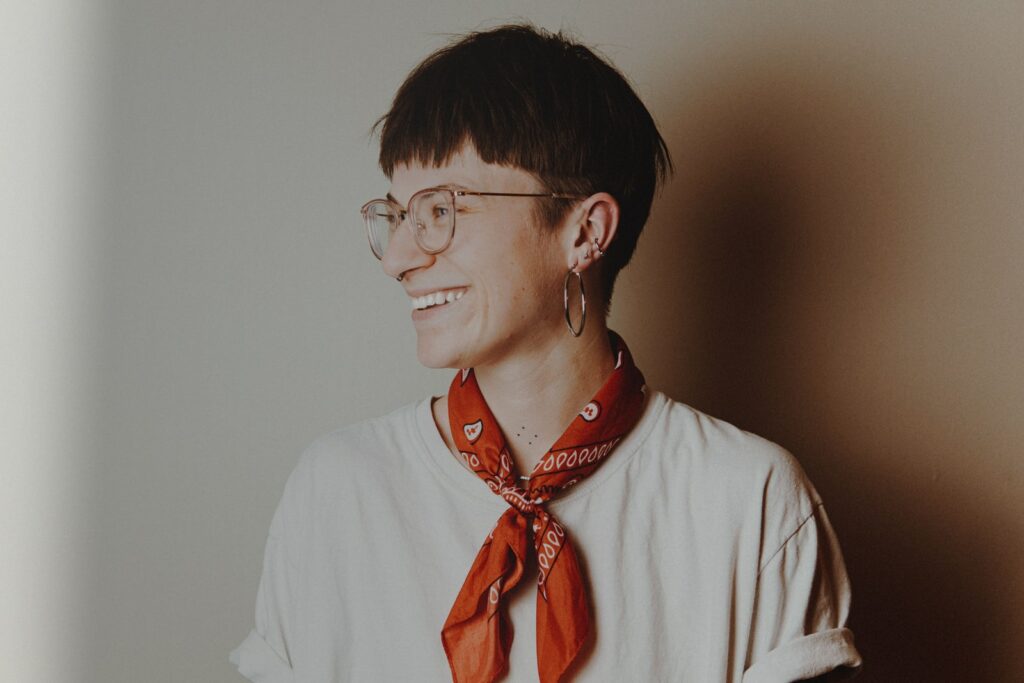 homem de camisa branca vestindo óculos com moldura vermelha e preta