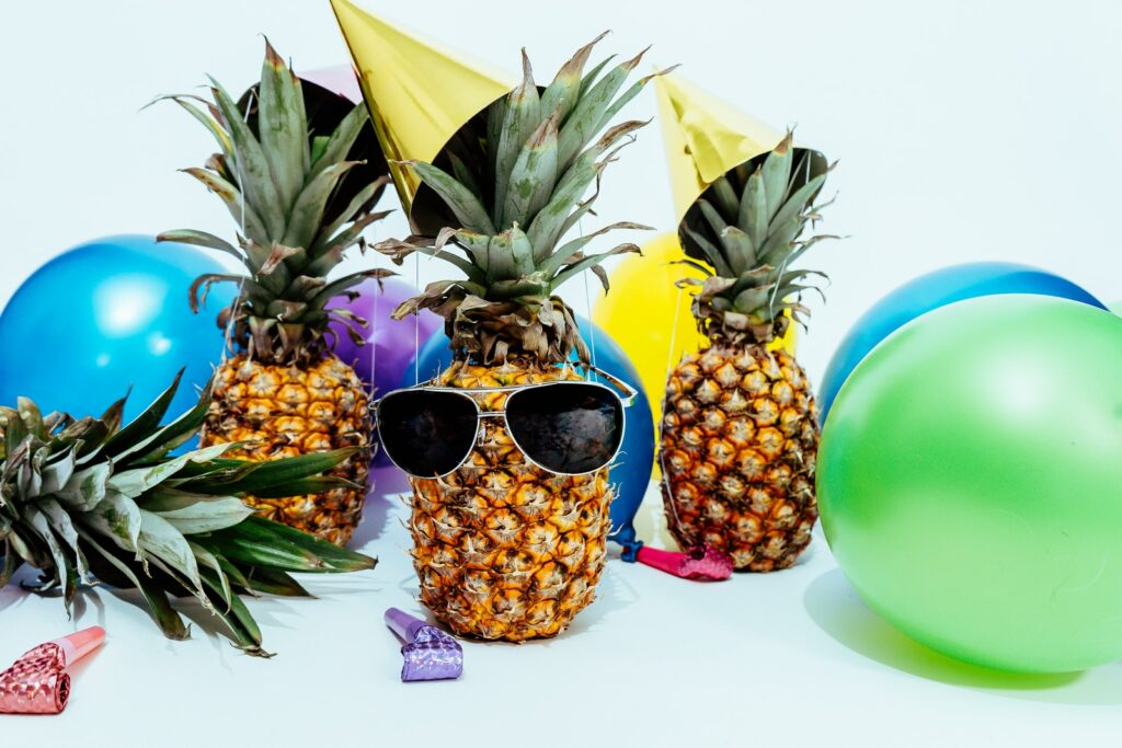 Photo de trois ananas entourés de ballons